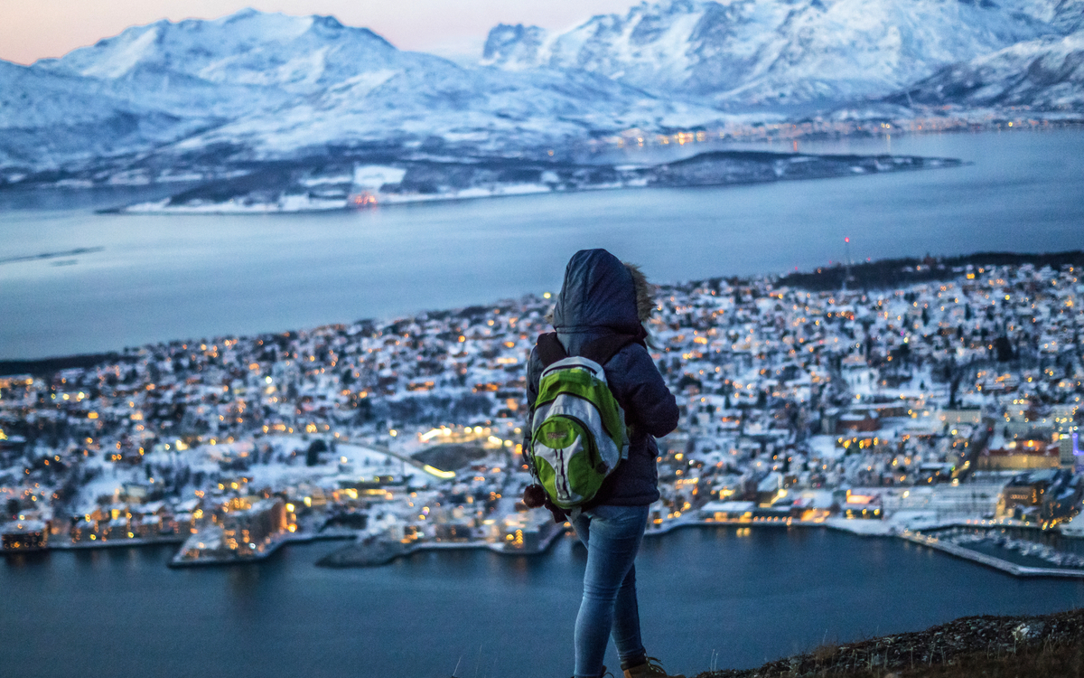 Reisende auf dem Gipfel des Berges in Tromsø im Winter