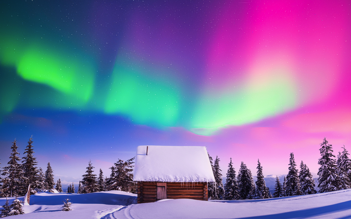 Winterlandschaft mit Pfad im Schnee und Holzhütte unter Nordlichtern am Nachthimmel